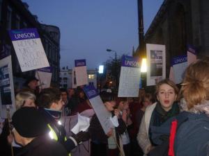 Group of women marching with placards reading 'Women Unite Reclaim the Night'